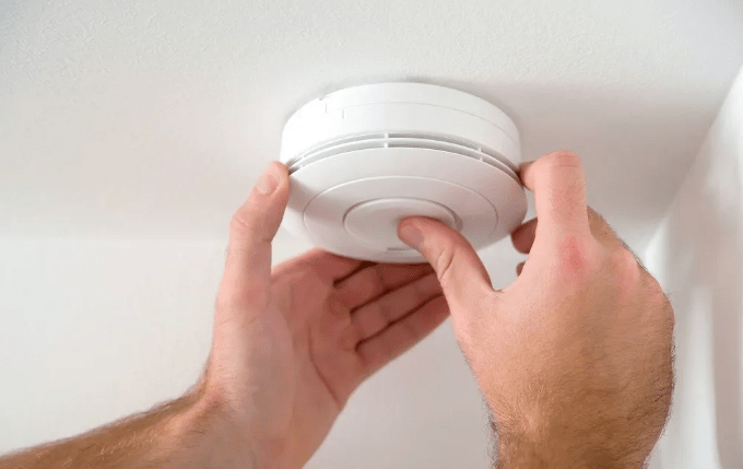 Man installing smoke alarm